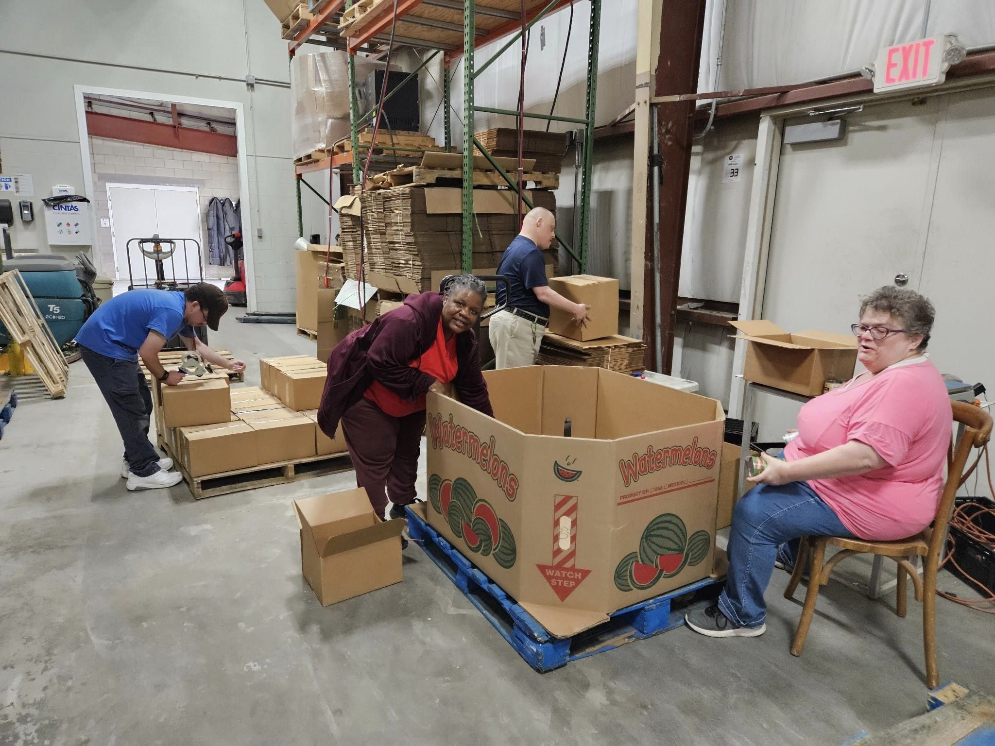 Team of volunteers packing boxes in a warehouse workspace.