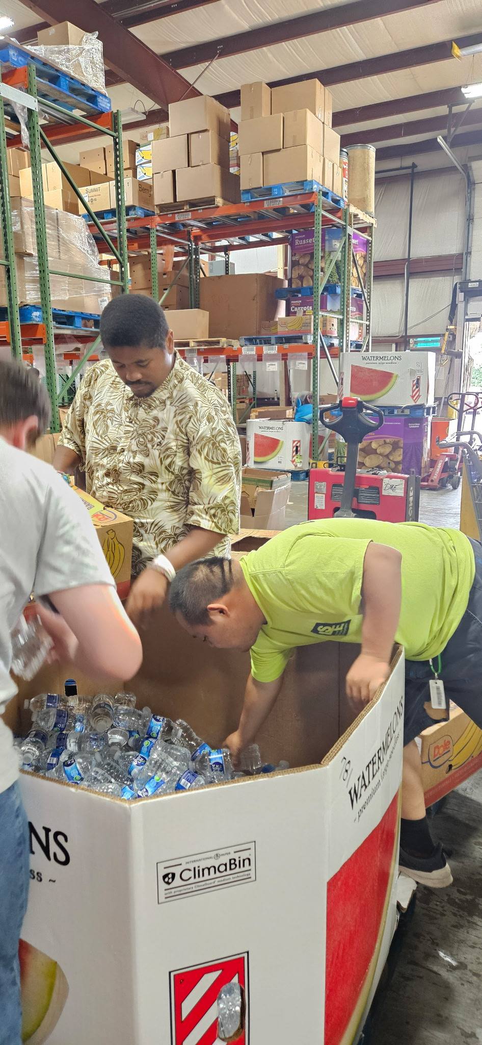 Team sorting water bottles from a large bin in the warehouse